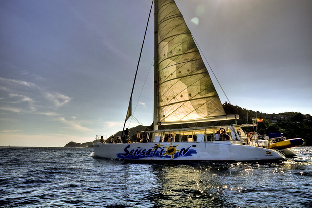 Lloret de Mar: Crociera in catamarano al tramonto con DJ e bevande